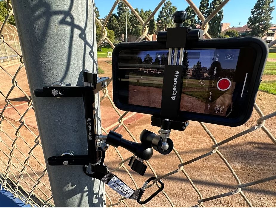 FenceClip Post Mount clamped to a chain-link fence post holding an iPhone